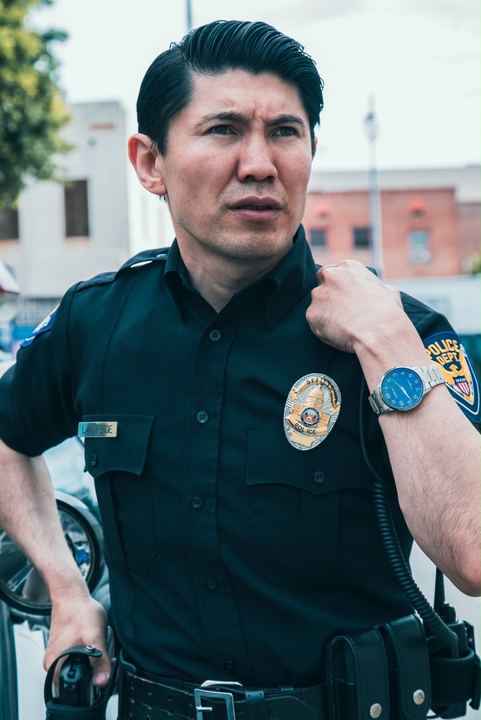 Medet in uniform with his hand on his shoulder, looking to the right