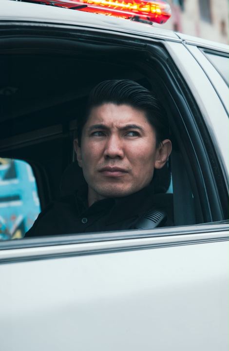 Medet in the window of a patrol car with the light bar glowing red